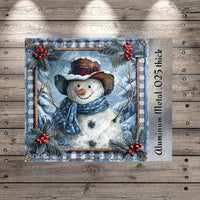 A snowman wearing a hat and scarf, surrounded by holly leaves and berries, is depicted in a decorative frame against a snowy winter landscape.
