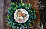 a wreath made of green foliage and a white sign with a rooster and the text "Making a List Chicken IT TWICE". The sign is surrounded by a wreath, creating a festive and decorative arrangement.