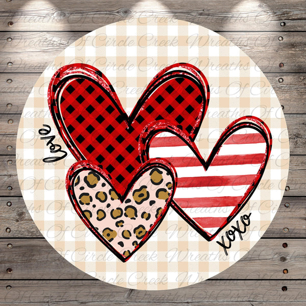 A circular design featuring three heart-shaped illustrations with different patterns and colors, including red and black plaid, leopard print, and stripes.