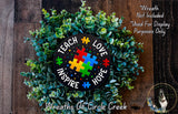 A wreath made of green leaves and a black circular sign with puzzle pieces and the words "Teach Love Inspire Hope" written on it.