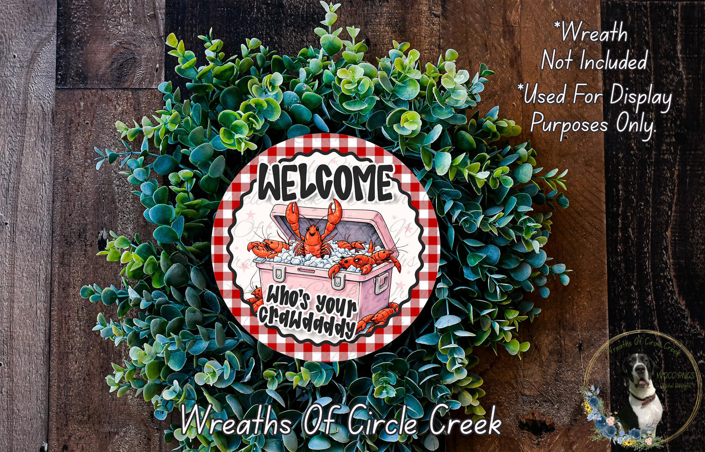 a wreath made of green foliage and a red and white sign that says "Welcome Who's your Crabdaddy". The sign is surrounded by a wreath, creating a festive and welcoming atmosphere.