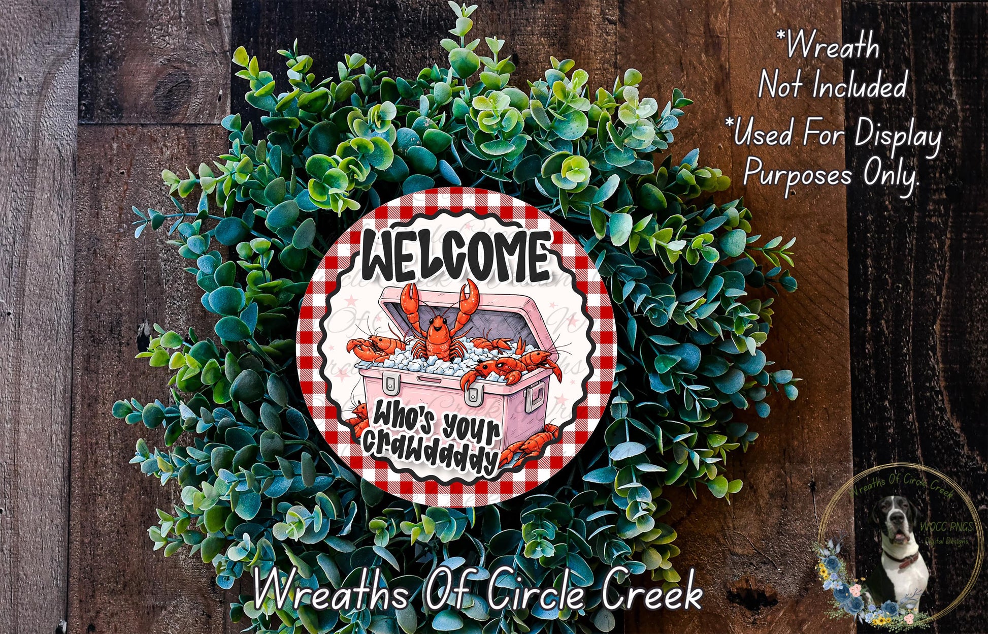 a wreath made of green foliage and a red and white sign that says "Welcome Who's your Crabdaddy". The sign is surrounded by a wreath, creating a festive and welcoming atmosphere.