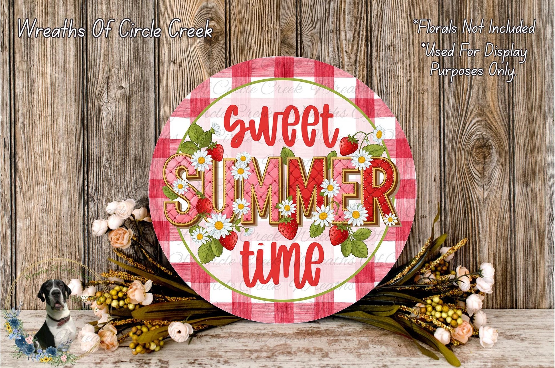 a decorative sign with the text "Sweet summer time" surrounded by flowers and greenery, placed on a wooden surface.