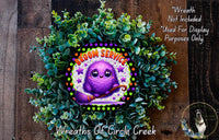 A wreath made of green leaves and a purple fairy with a broom, featuring the text "Groom Service" and "Wreaths of Circle Creek".