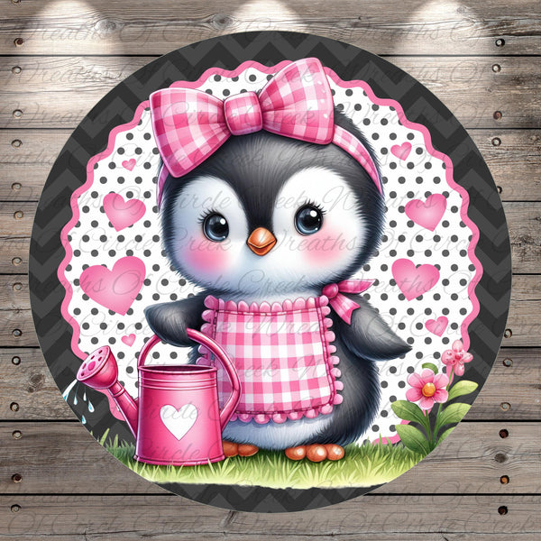 A cute cartoon penguin wearing a pink bow and apron, holding a pink watering can, surrounded by hearts and flowers on a wooden background.