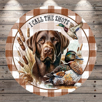 A brown dog is depicted in the center of the image, surrounded by a duck and reeds, with the text "I CALL THE SHOTS" written above the dog.