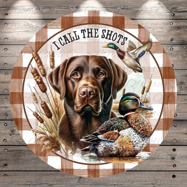 A brown dog is depicted in the center of the image, surrounded by a duck and reeds, with the text "I CALL THE SHOTS" written above the dog.