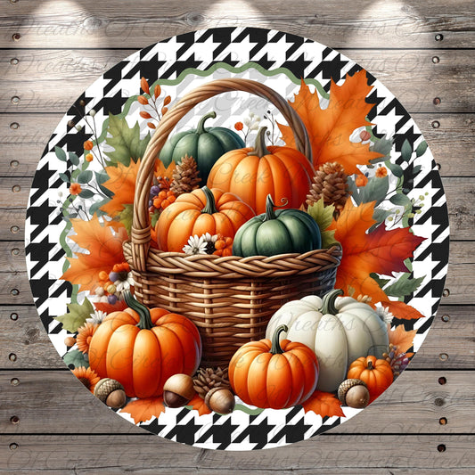 A round, decorative plate featuring a basket filled with pumpkins, acorns, and leaves, surrounded by a houndstooth pattern.