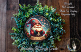 A wreath featuring a Santa Claus figure surrounded by greenery, with a "Welcome" sign in the center. The wreath is displayed on a wooden surface, and there is a text overlay that reads "Wreath Not Included * Used For Display Purposes Only".