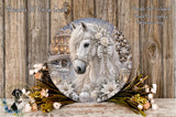 A decorative round plate featuring a white horse adorned with flowers and a bridge in the background, placed on a wooden surface.