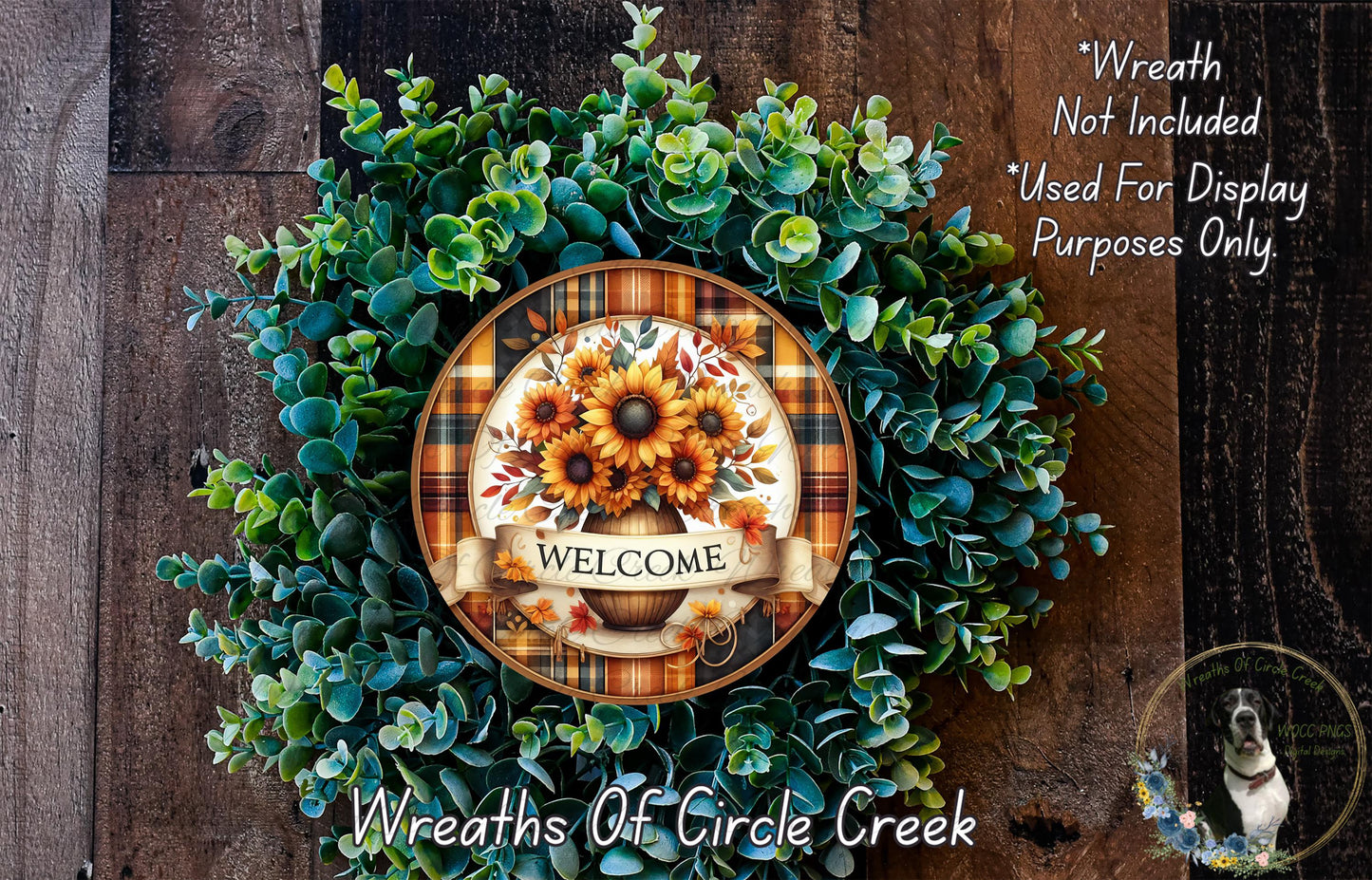 a wreath made of various green plants and flowers, with a decorative plate in the center displaying the word "WELCOME".