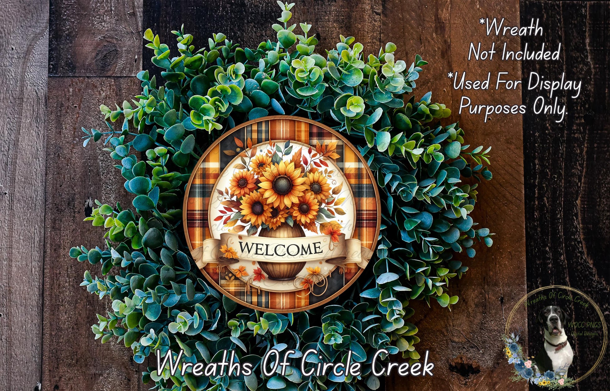 a wreath made of various green plants and flowers, with a decorative plate in the center displaying the word "WELCOME".