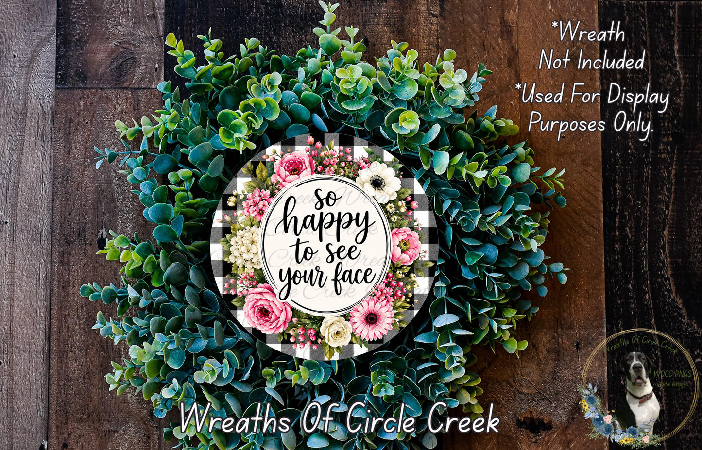 A wreath made of various green and pink flowers, with a sign that says "So happy to see your face" in the center.