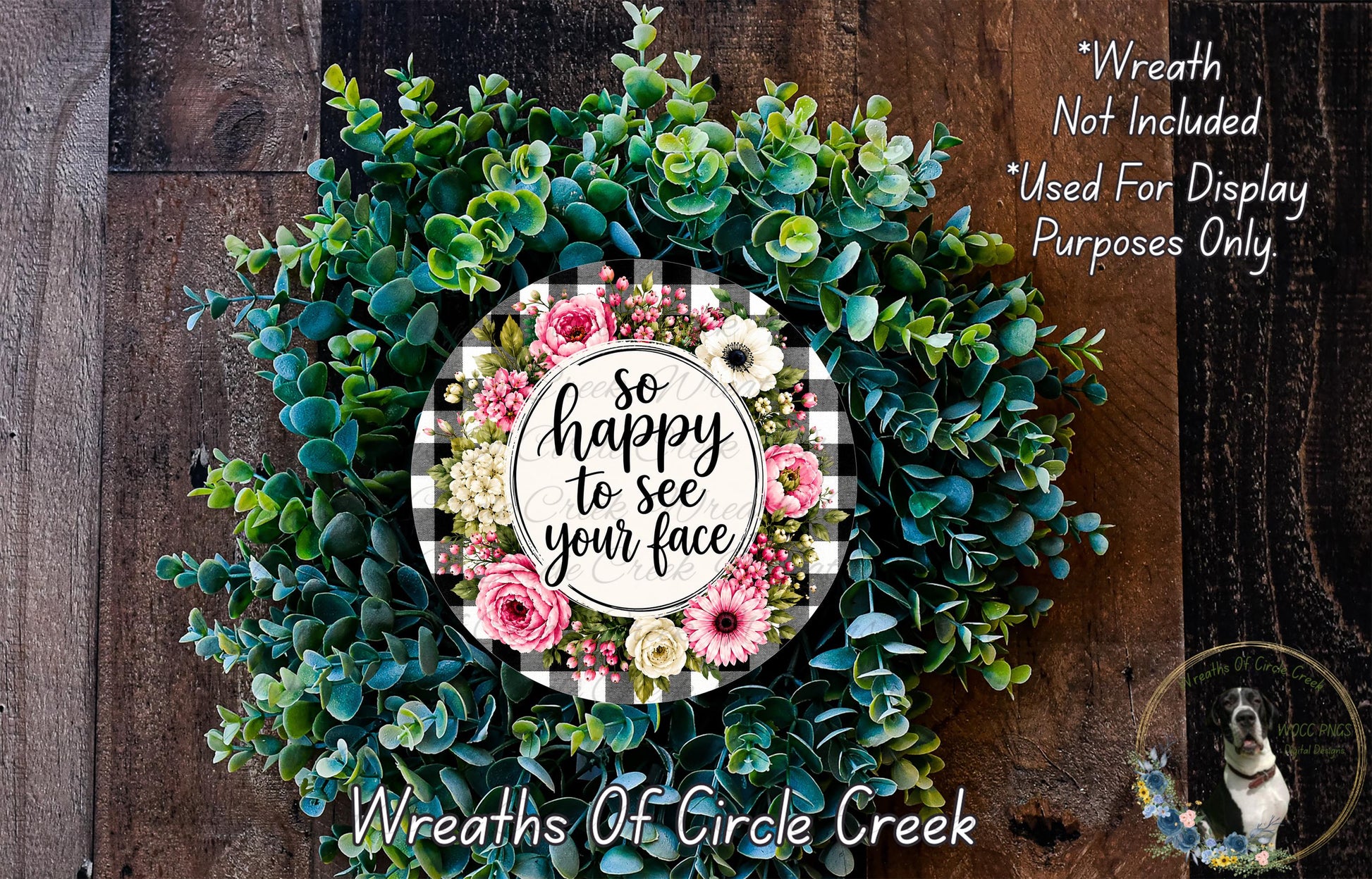 A wreath made of various green and pink flowers, with a sign that says "So happy to see your face" in the center.