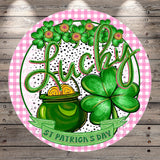 A circular design featuring a pot of gold coins, a clover, and the word "Lucky" written in cursive. The background is a pink and white checkered pattern.