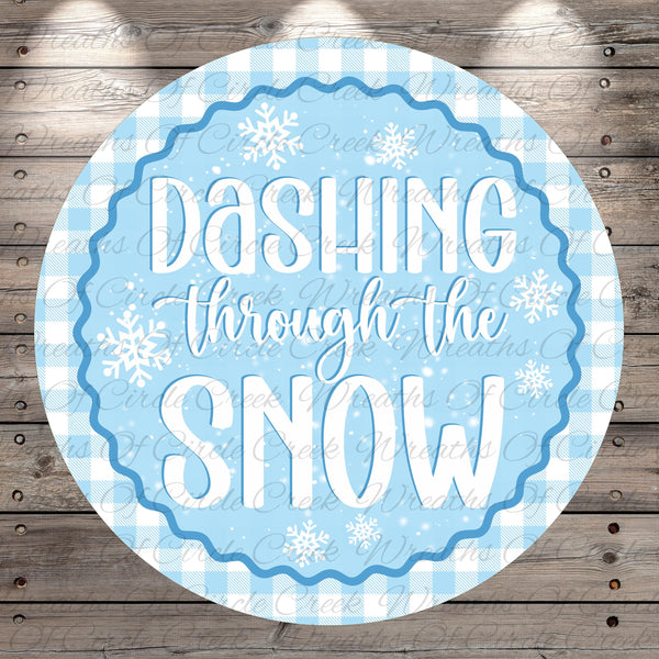 A circular sign with the text "DASHTING THROUGH THE SNOW" written in a decorative blue and white font, surrounded by snowflake-like designs.