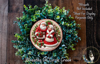 A Christmas wreath with Santa Claus and his reindeer, surrounded by greenery, and a text overlay that reads "Merry Christmas" and "Wreaths of Circle Creek".