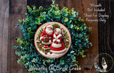 A Christmas wreath with Santa Claus and his reindeer, surrounded by greenery, and a text overlay that reads "Merry Christmas" and "Wreaths of Circle Creek".