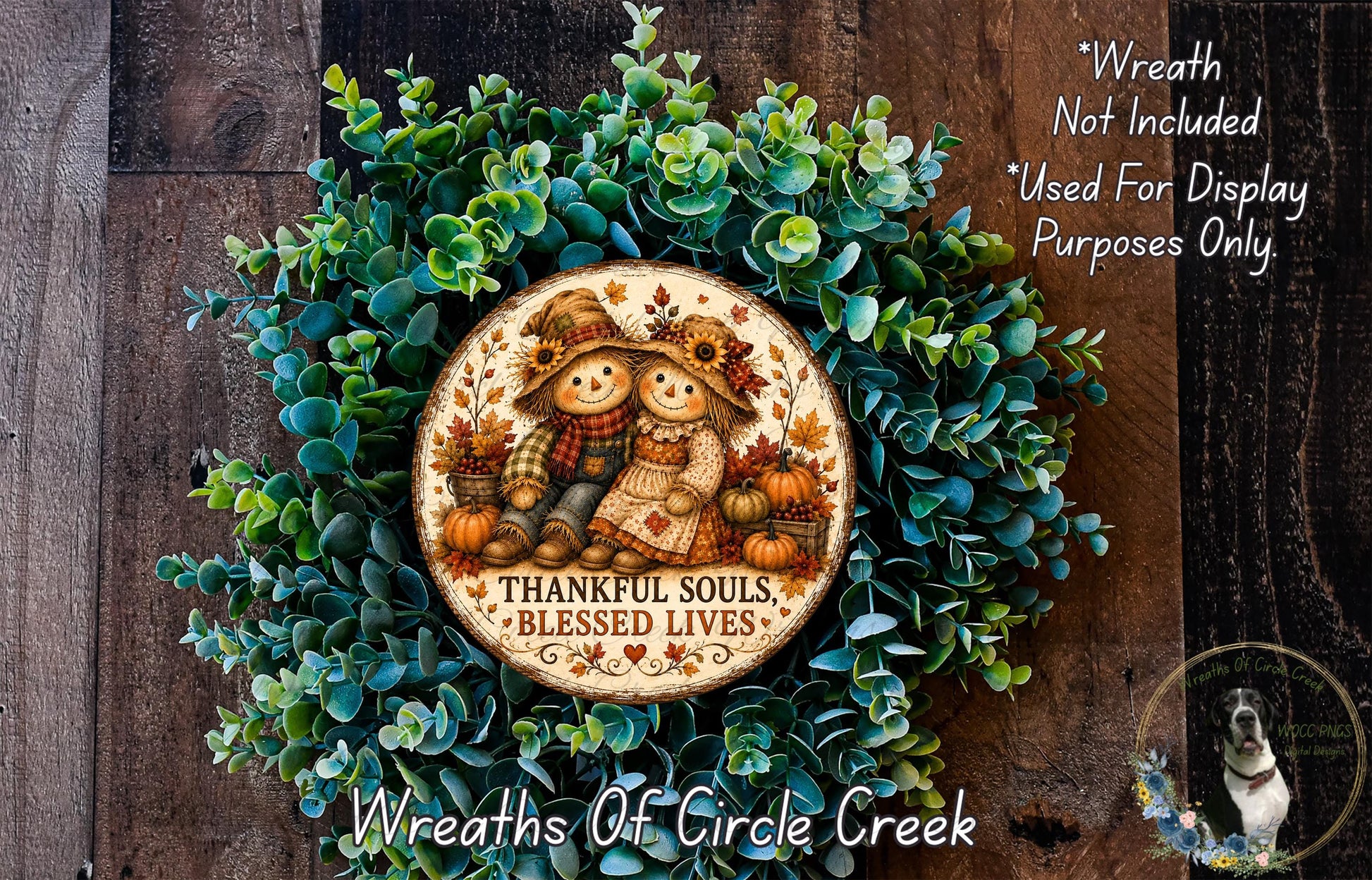a wreath made of green leaves and a circular plaque with a design of two scarecrow figures and the text "Thankful Souls, Blessed Lives" on it.