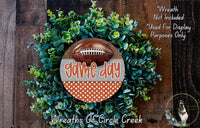 a wreath made of green foliage and a football, with the text "game day" prominently displayed on the wreath.