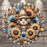 A cheerful scarecrow surrounded by a vibrant wreath of sunflowers and autumn leaves, with the word "THANKFUL" displayed below.