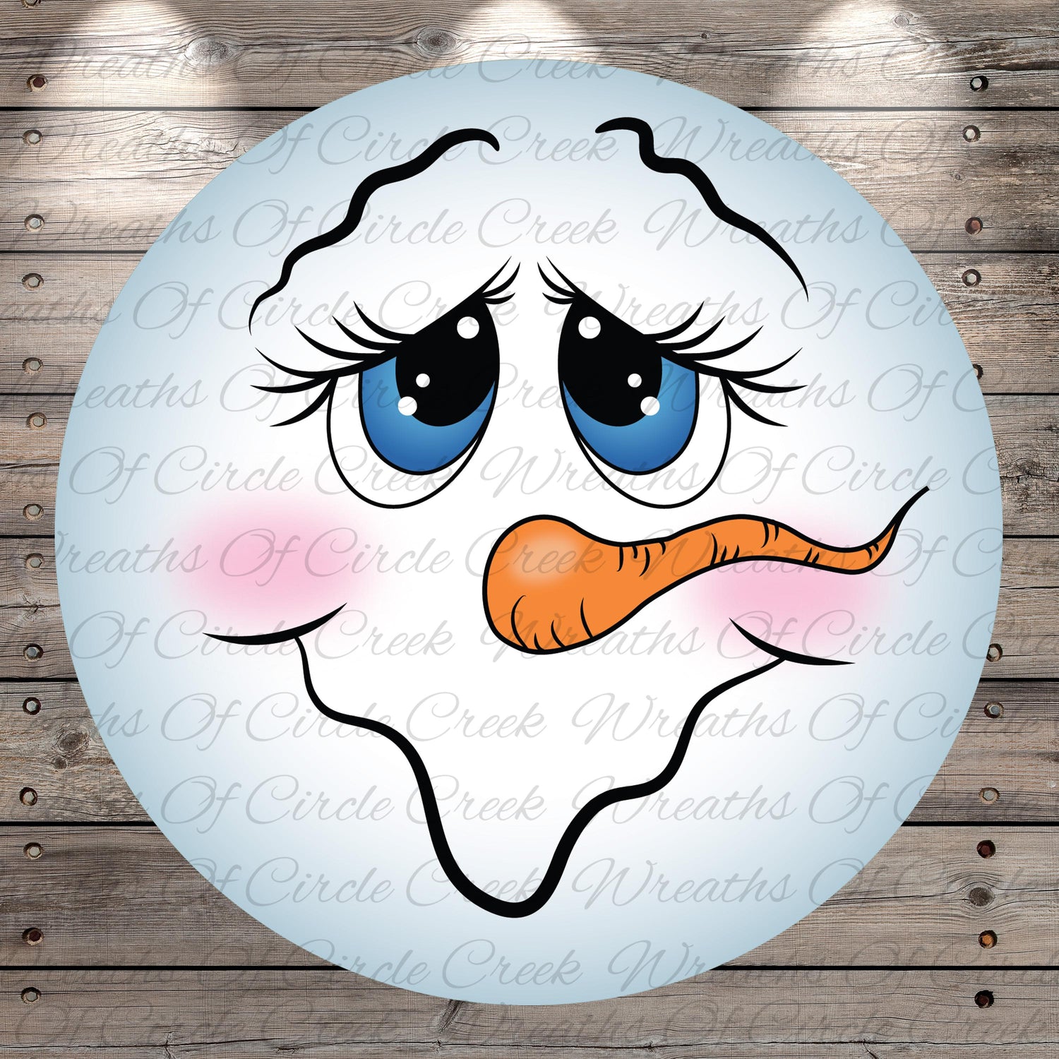 A snowman face with large blue eyes, a carrot nose, and a pink nose is displayed against a wooden background.