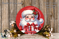A festive Christmas-themed image featuring a large Santa Claus figure holding a gift box, surrounded by a wreath of flowers and greenery against a wooden background.