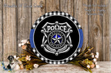 a police badge with a shield design, surrounded by flowers and a wooden background.