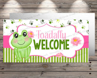 a welcome sign with a frog sitting on top of it