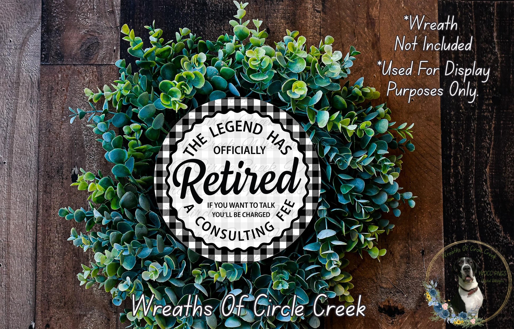 a wreath made of green leaves and a circular sign with text, placed on a wooden surface.