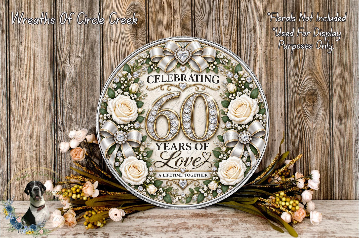 A decorative sign celebrating 60 years of love, featuring a floral design with roses and greenery, placed on a wooden surface with a wreath of flowers and greenery.