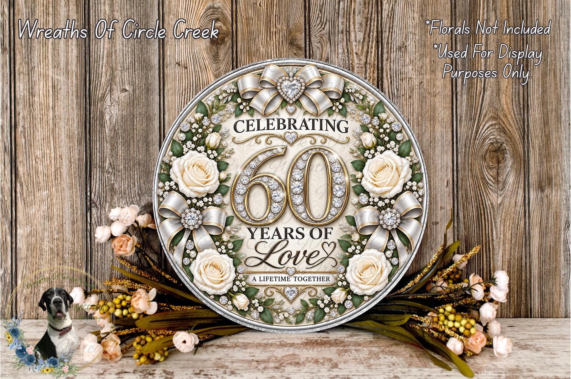 A decorative sign celebrating 60 years of love, featuring a floral design with roses and greenery, placed on a wooden surface with a wreath of flowers and greenery.