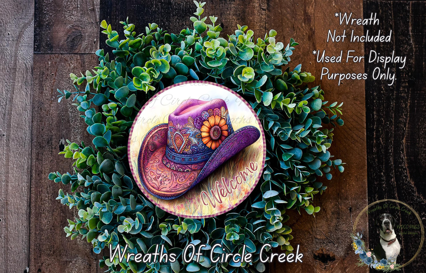 a wreath with a cowboy hat on it, surrounded by greenery. The wreath is placed on a wooden surface, and there is a text overlay that reads "Welcome Wreath Not Included * Used For Display Purposes Only".