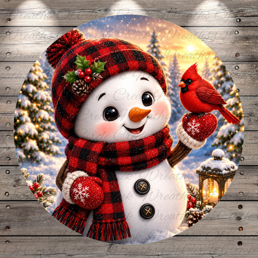 A cheerful snowman wearing a red and black plaid hat, scarf, and mittens, with a red cardinal perched on its left hand. The snowman is surrounded by a snowy landscape with pine trees and a lantern, creating a festive winter scene.