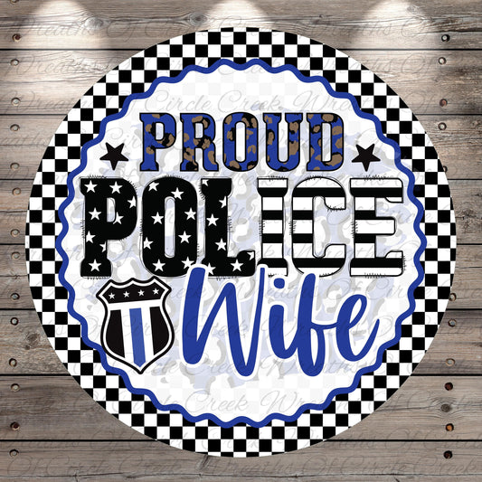 a circular design with a checkered border and a police officer's badge symbol. The text "Proud Police Wife" is prominently displayed in the center of the design.