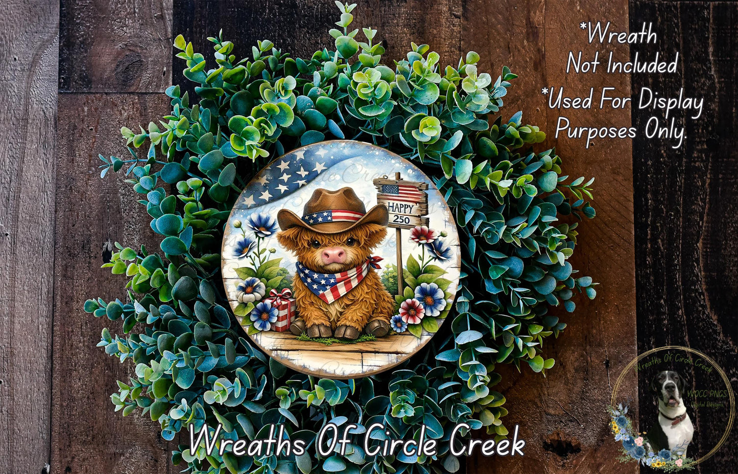 A wreath featuring a cow wearing a cowboy hat and an American flag, surrounded by greenery and flowers.