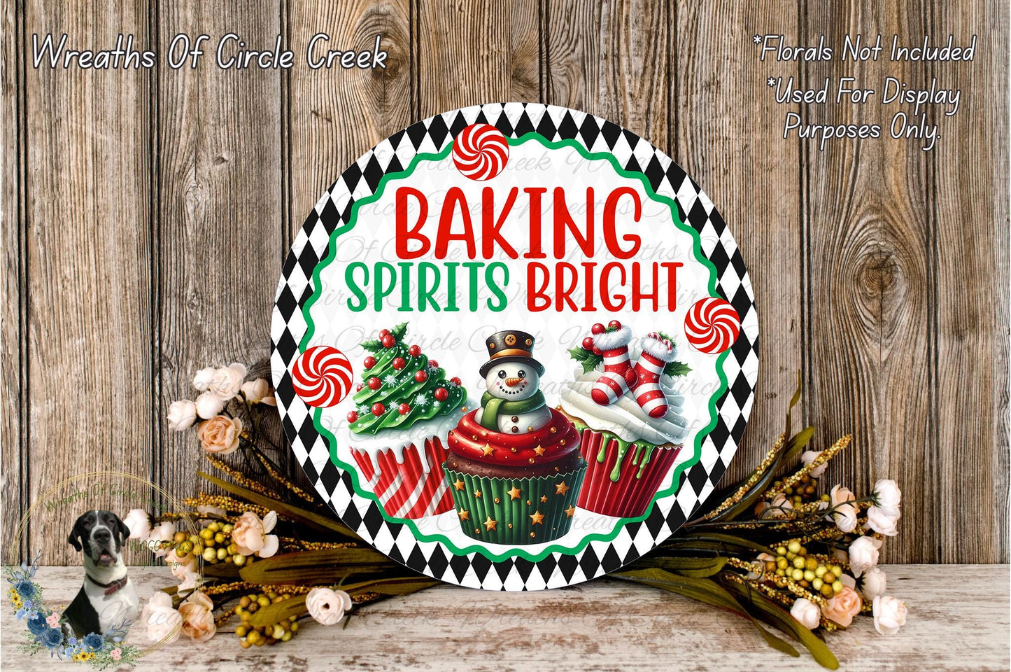 A decorative sign with the text "Baking Spires Bright" and illustrations of a snowman, cupcakes, and a Christmas tree, surrounded by a wreath of flowers and greenery.