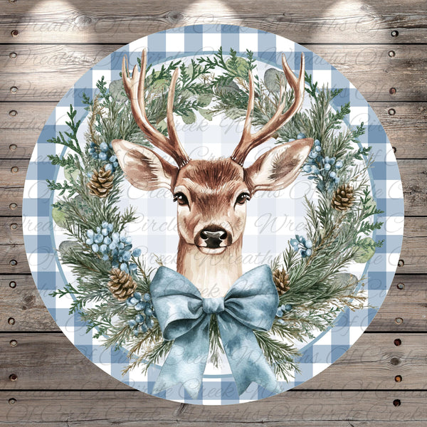 A deer head is depicted in a wreath made of pine cones, pine needles, and berries, with a blue ribbon bow.
