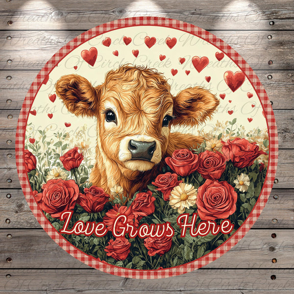 A cow surrounded by red roses and hearts, with the text "Love Grows Here" written around the image.