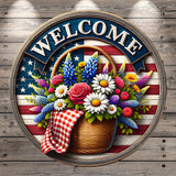 A circular welcome sign with a basket of flowers and a red and white checkered cloth, set against an American flag background.