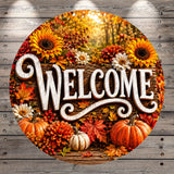 A circular welcome sign with the word "WELCOME" written in a decorative font, surrounded by autumn-themed elements such as sunflowers, pumpkins, and leaves.