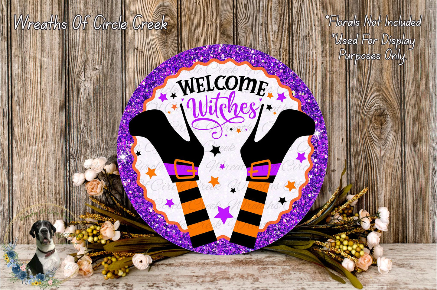 a decorative sign with the text "Welcome Witches" and a pair of witch's boots, surrounded by a floral arrangement and a wooden background.