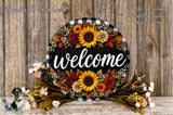 a decorative welcome sign with a floral arrangement, placed on a wooden surface. The sign is surrounded by various fall-themed flowers, creating a warm and inviting atmosphere.