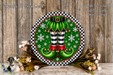 A festive wreath with a green elf's feet and red and gold boots, surrounded by snowflakes and flowers, against a wooden background.