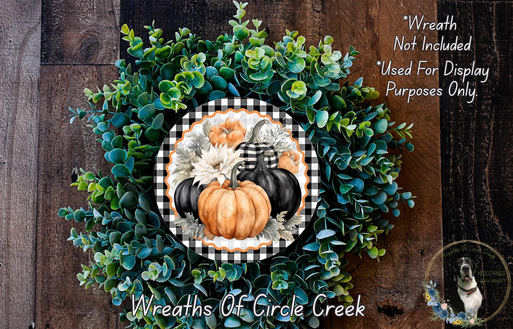 a wreath made of various fall-themed elements, including pumpkins, greenery, and a black and white checkered border. The wreath is displayed on a wooden surface, and there is a small dog visible in the bottom right corner of the image.