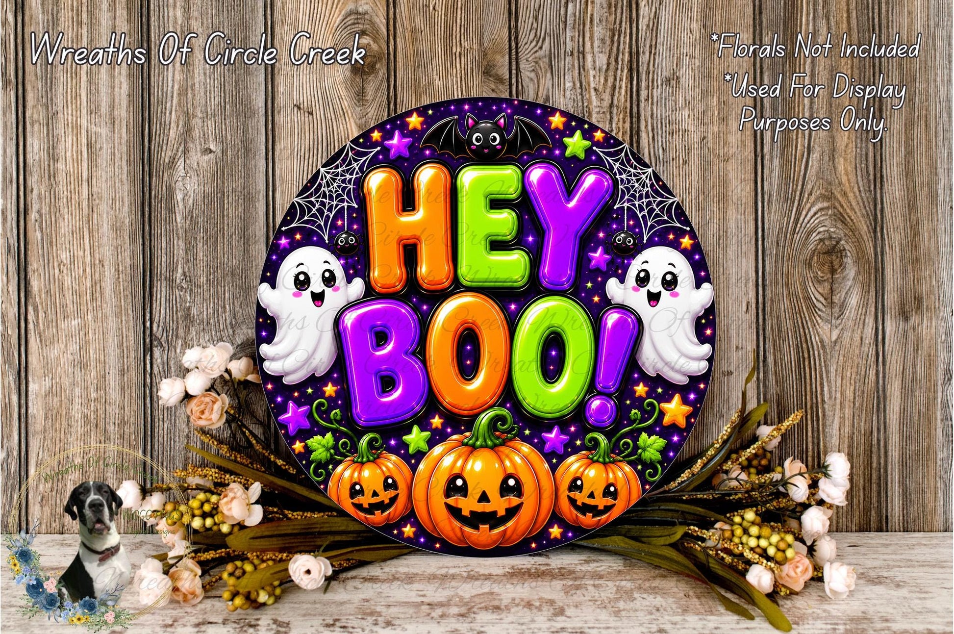 a Halloween-themed sign with the text "Hey Boo!" surrounded by various Halloween-related elements such as pumpkins, bats, and ghostly figures. The sign is displayed on a wooden surface, with a floral arrangement and some flowers nearby.