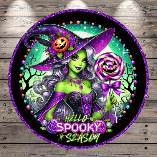 A colorful illustration of a woman with purple hair and a purple witch hat, holding a lollipop and surrounded by Halloween-themed elements such as pumpkins, bats, and stars.