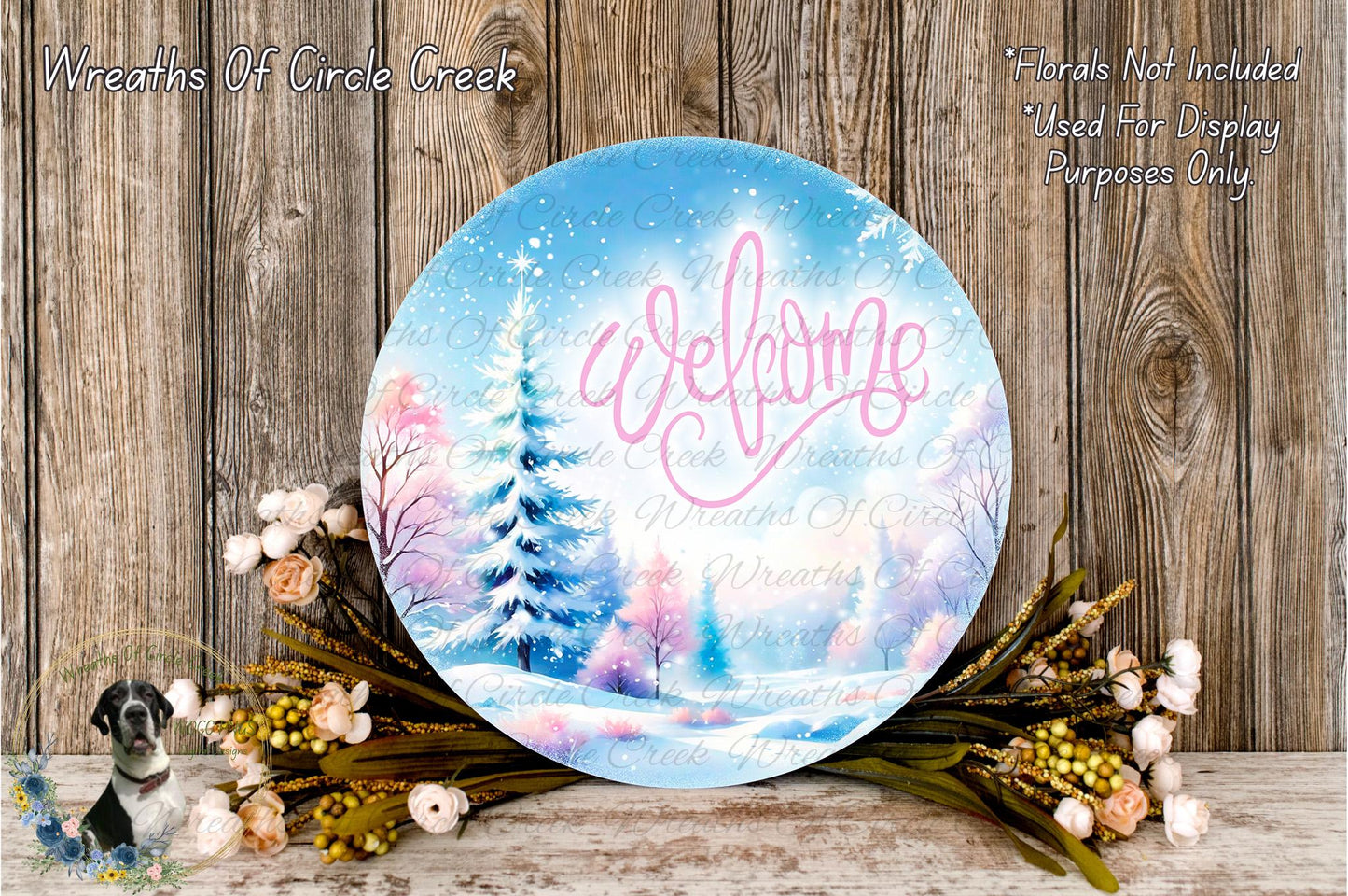 a round, blue sign with the word "Welcome" written on it, surrounded by a wreath of flowers and a snowy landscape.