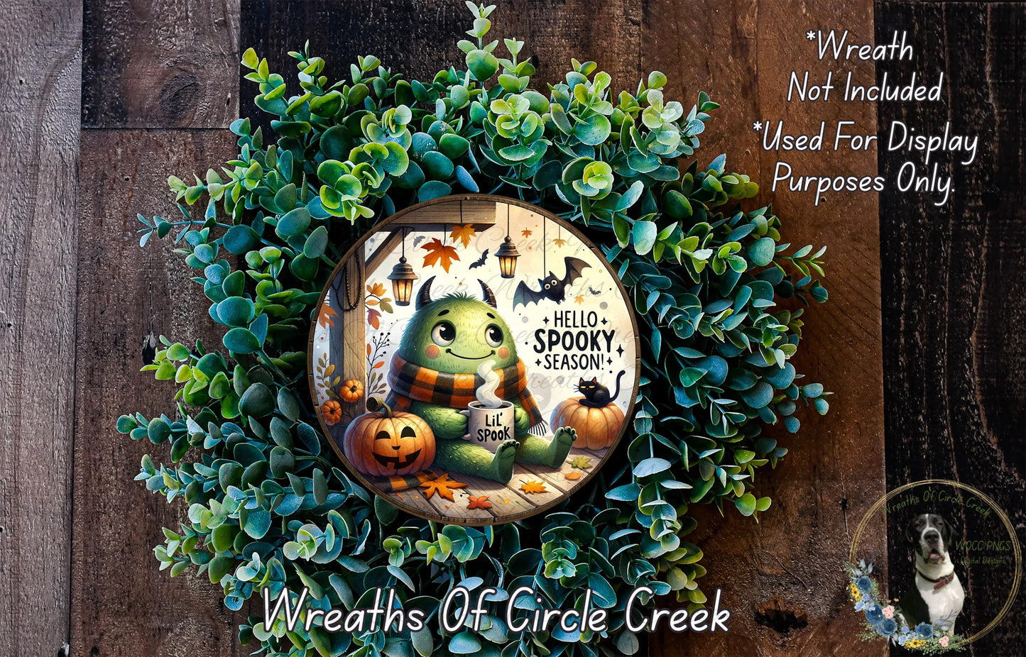 A wreath made of green leaves and a carved pumpkin, featuring a cartoon monster with a friendly expression and the text "Hello Spooky Season!"