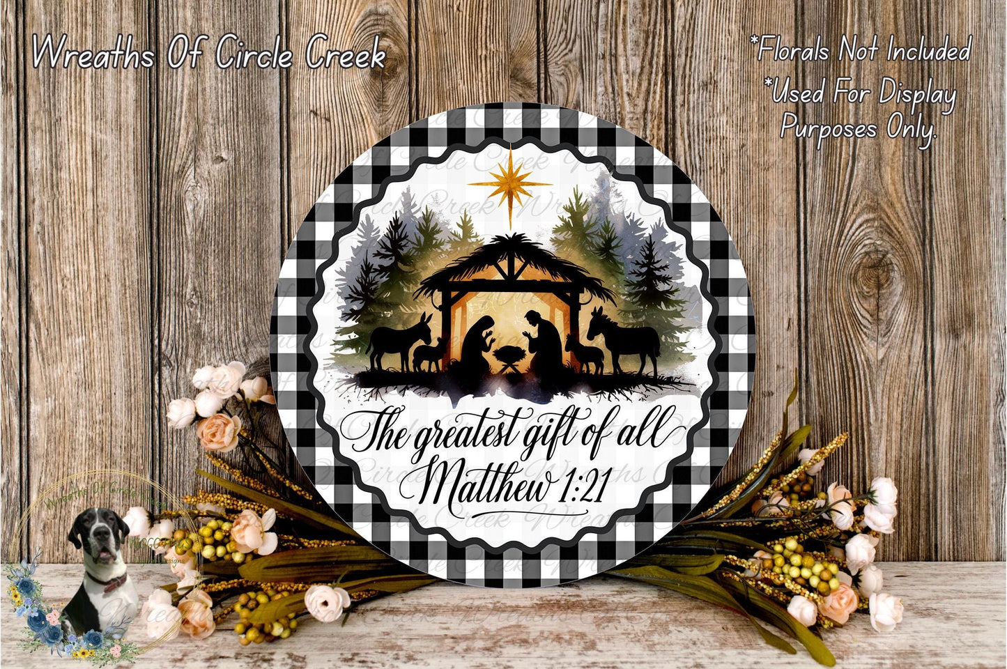 a decorative plate with a nativity scene and a quote about the greatest gift of all, Matthew 1:21. The plate is surrounded by a floral arrangement and a wooden background.